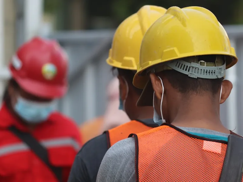 Sekelompok pekerja industri mengenakan helm keselamatan di area kerja